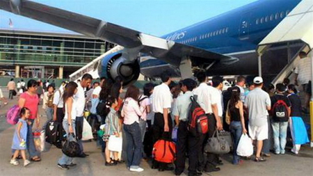 Hành khách chuẩn bị lên máy bay của VNA ở sân bay Tân Sơn Nhất.